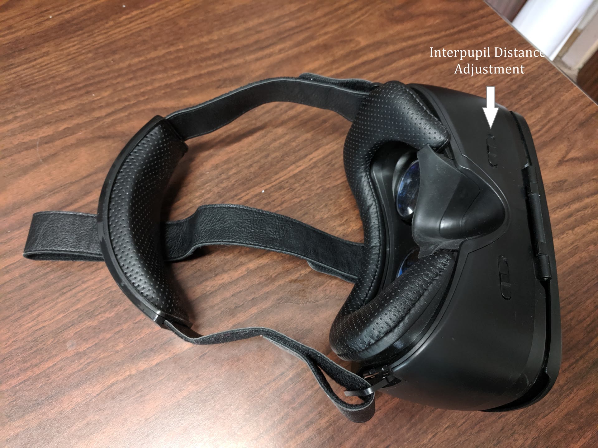 Black VR headset seen from below with the interpupil distance adjustments labeled