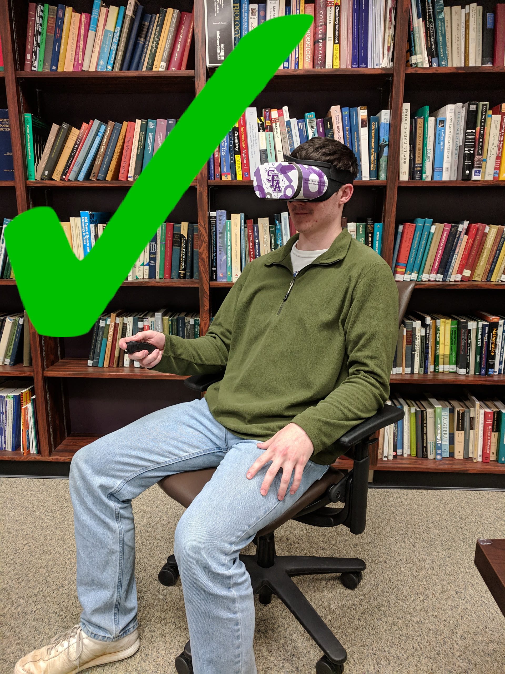 Person using a VR headset while seated in a chair, marked with a green check mark