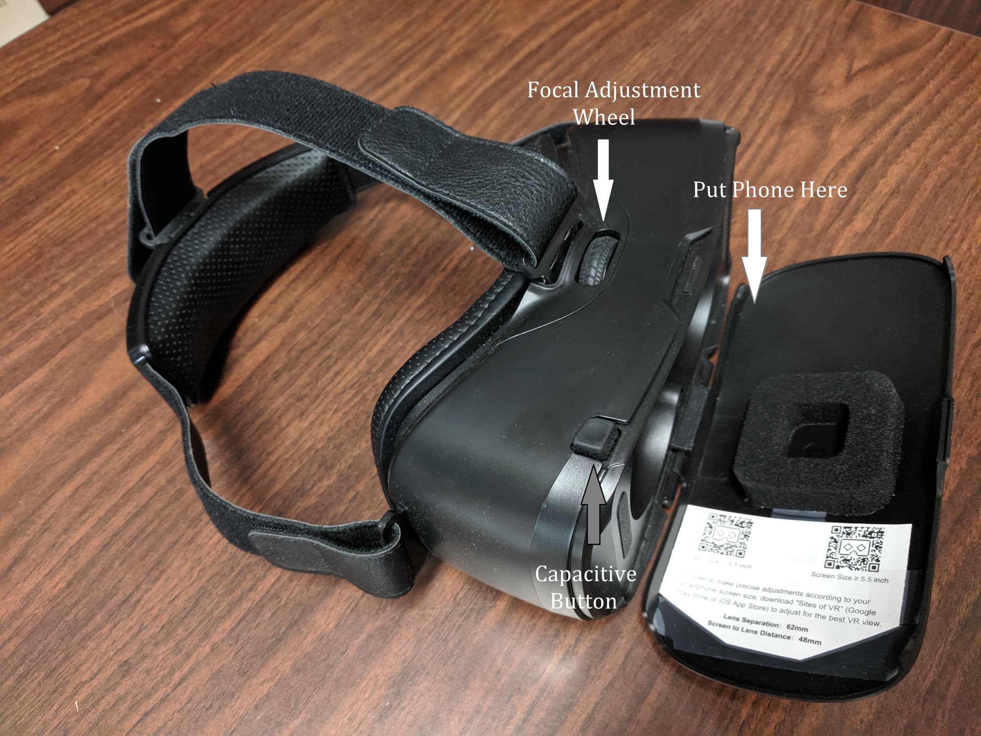 Black VR headset with the focal adjustment wheel and phone position labeled